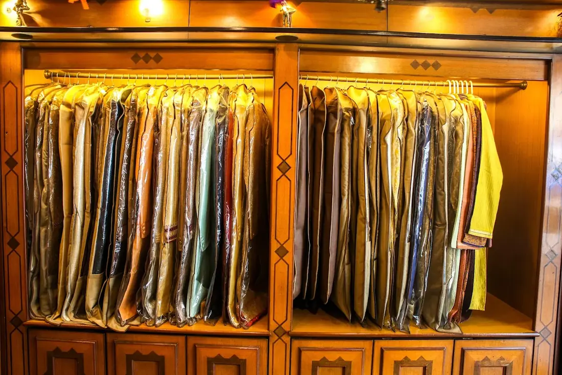 Close view of covered garments on a brass rail